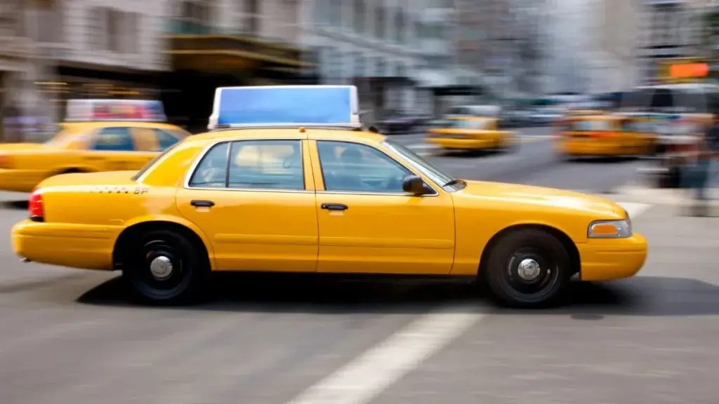 A yellow taxi driving along a city street.