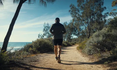 person walking a eucalyptus-lined coastal bush track
