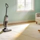 Bright Australian family living room with a cream carpet in a sunbeam and a vacuum cleaner standing ready