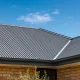 A grey metal roof on an Australian home under a bright blue sky.
