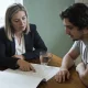 NDIS support coordinator and participant reviewing a printed plan together at a timber kitchen table in an Australian home